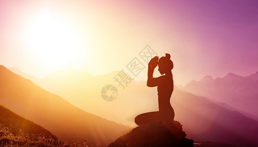 自然日出山顶上锻炼瑜伽的女性设计图片
