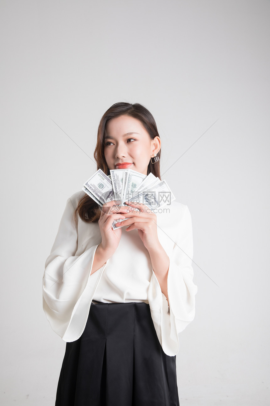 年轻美女拿着美钞外币图片
