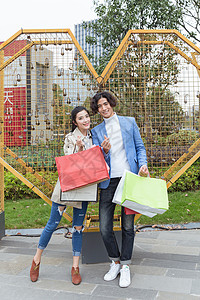 年轻夫妻在快乐的购物背景图片