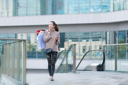 女性手提购物袋消费背景图片