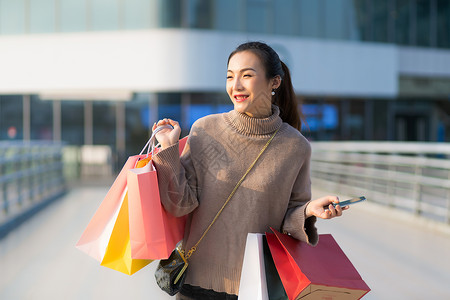 女性手提购物袋消费背景图片