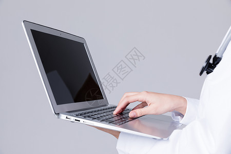 医生使用电脑年轻医生操作笔记本电脑背景