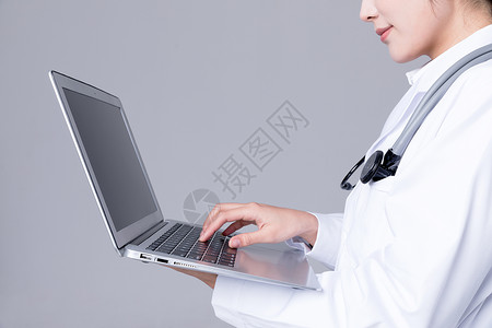 医生使用电脑年轻医生操作笔记本电脑背景