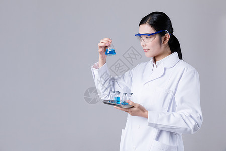 液体药瓶年轻医生手拿医药托盘药瓶液体背景