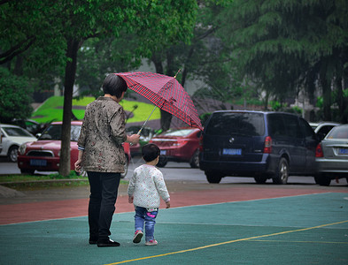 撑着雨伞孩子雨中给孩子打伞的妈妈背景