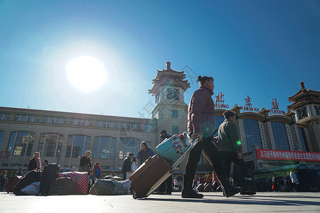 扛着行李回家的人北京站坐火车回家的人背景