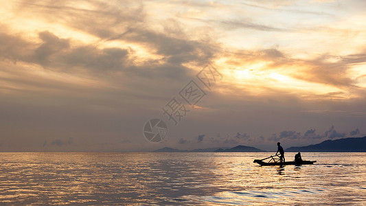 傍晚海滩夕阳下海边辛勤劳动的渔民背景