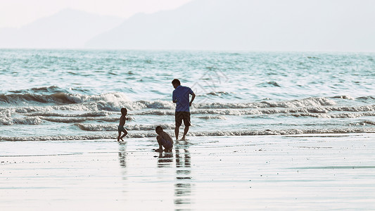 海边小孩在海边参加亲子活动的幸福的一家人背景