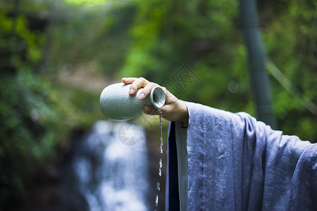 绿色衣服素材手拿酒壶倒出的酒背景