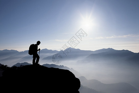 登上山顶俯视群山的人背景图片