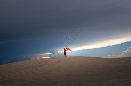 一望无际沙漠里的红衣美女背影背景图片