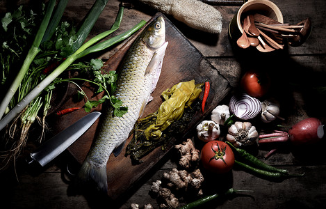 一盘青菜一整条鱼和食材背景