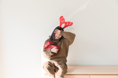 麋鹿帽子拿着圣诞礼物的甜美女生背景
