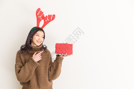 圣诞节拿着礼物的年轻女性背景图片