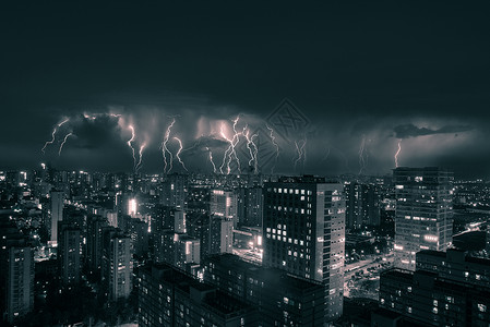 雷暴天气闪电下的城市夜景背景