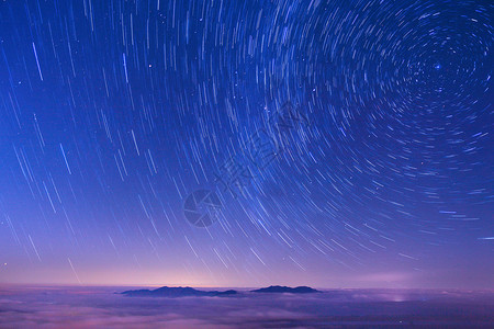 蓝色夜空中的星轨背景图片