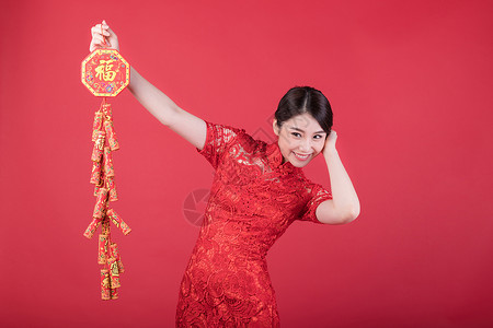 春节手拿福字鞭炮串的美女图片