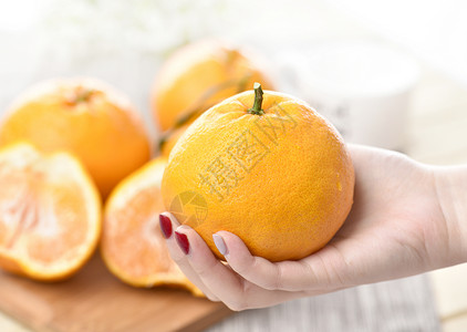 丑柑手拿橙子水果高清图片