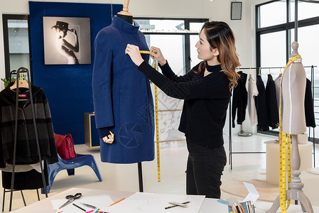 美女设计师测量服装设计工作室高清图片素材