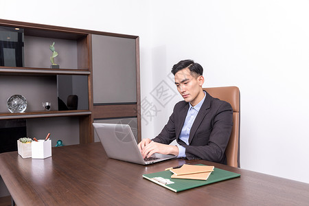 坐在办公桌前工作的商务人士背景图片