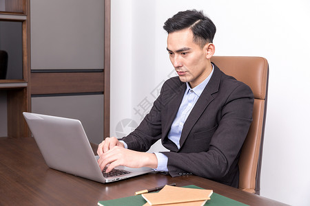 坐在办公桌前工作的商务人士背景图片