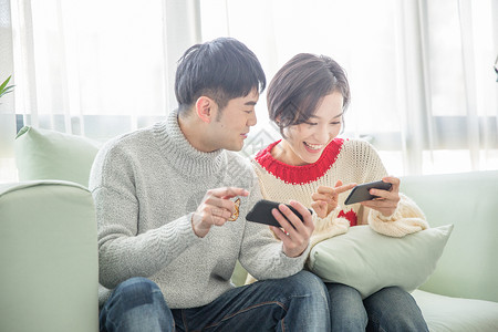 浪漫游戏居家年轻情侣在沙发上玩手机游戏背景