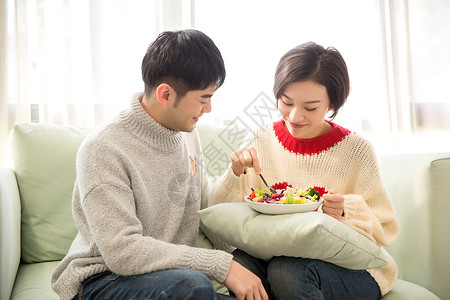 居家情侣在沙发上吃蔬菜沙拉图片