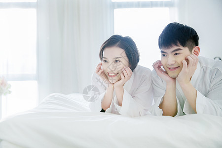 年轻夫妇穿浴袍在卧室图片