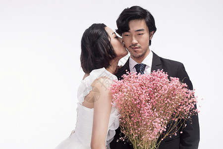 年轻情侣拍摄婚纱照亲吻背景图片