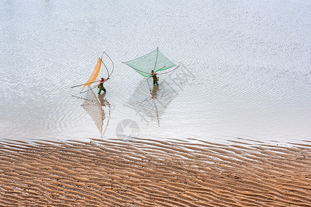 织渔网海中的渔民与沙滩背景