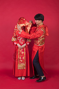 传统中式婚礼新郎掀起新娘的红盖头青年夫妇高清图片素材