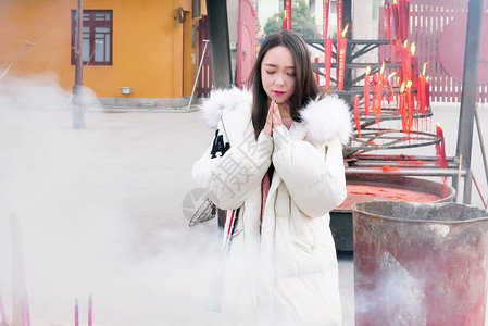 烧香女人寺庙正在请香的年轻美女信徒背景