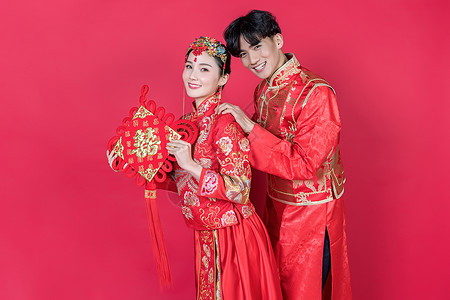 婚纱照中式情侣红妆手持中国结背景
