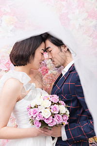 韩式服装花墙前的幸福年轻夫妻背景