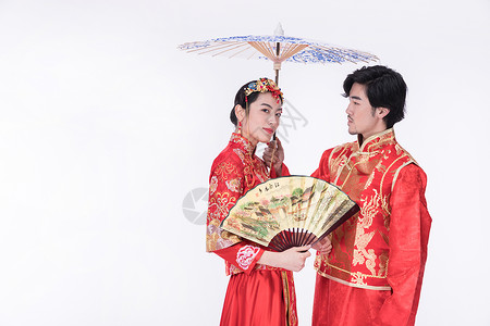身着中式礼袍的年轻夫妻撑伞图片