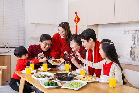 一家人新年吃年夜饭夹菜背景图片