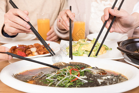 筷子夹菜一家人团聚吃饭吃鱼特写背景