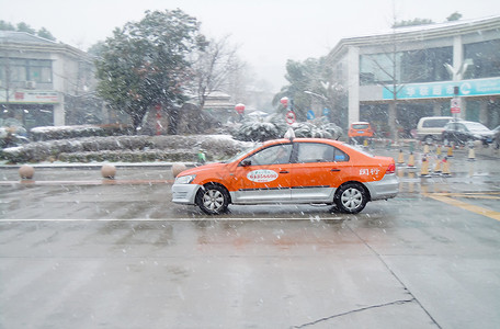 冬季飘雪雪花寒冷冬季雪中行驶的出租车背景