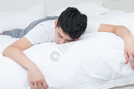 躺着的模特年轻男性沮丧地躺在床上背景