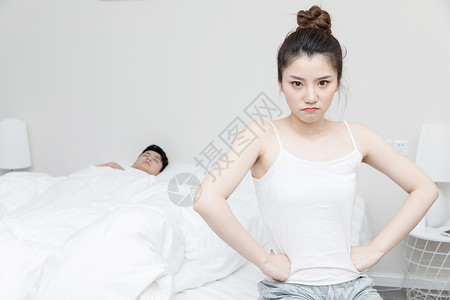 情侣吵架女朋友坐床边生气背景图片