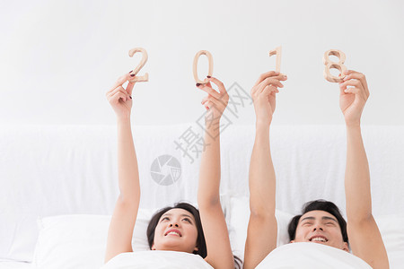 年轻夫妻躺床上手拿2018图片