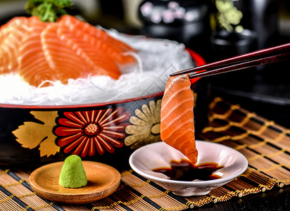 芥末筷子夹起来的三文鱼刺身背景