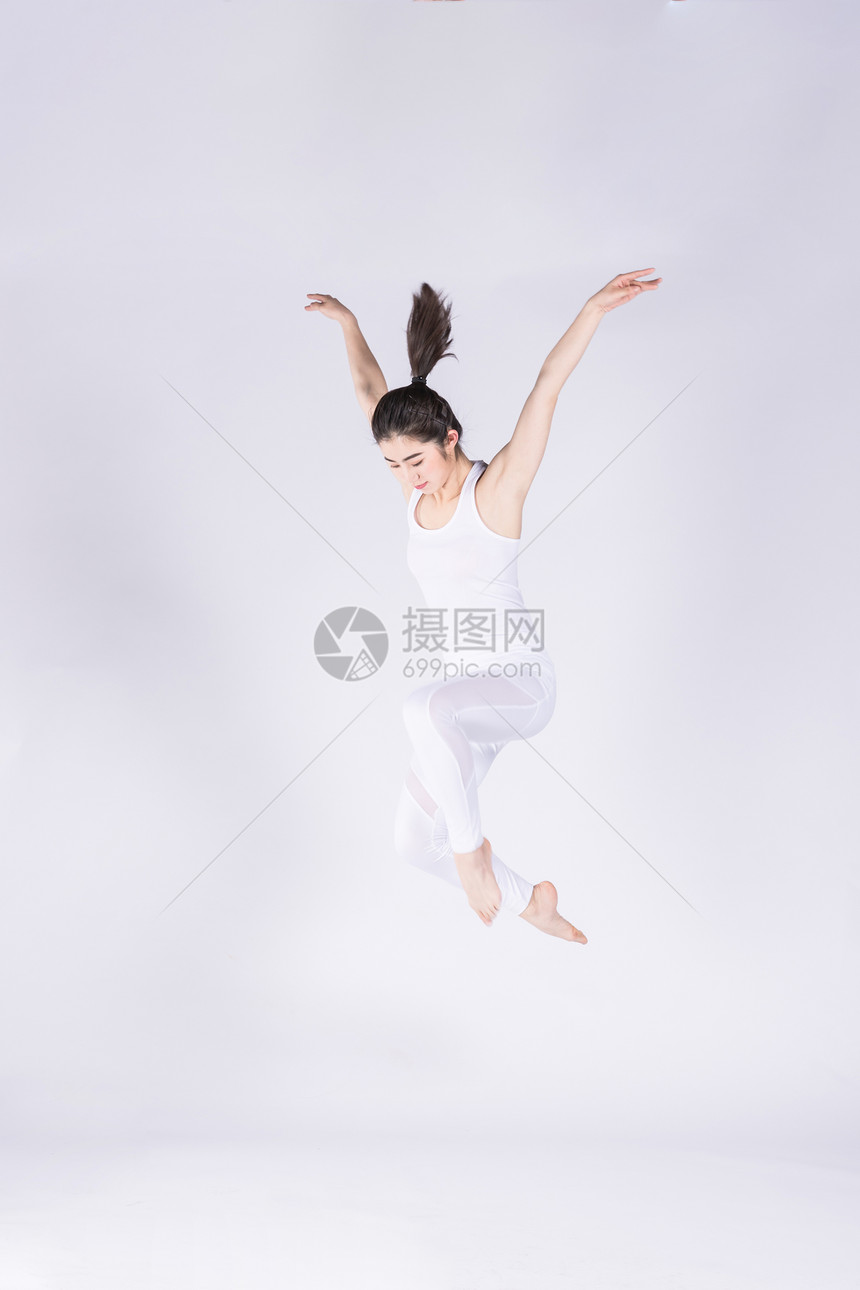 年轻女孩在做瑜伽跳跃图片