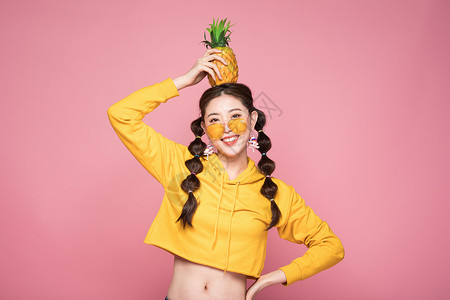 年轻双马尾女性头顶菠萝图片
