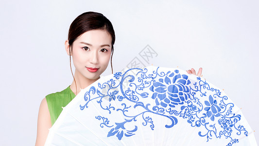 中式青花纹手持青花油纸伞的旗袍美女背景