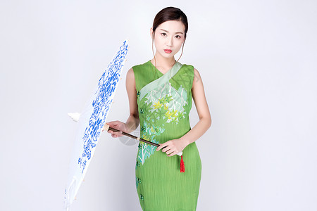 中式青花纹手持青花油纸伞的旗袍美女背景