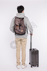 拉着行李箱背着书包的男生背影背景图片