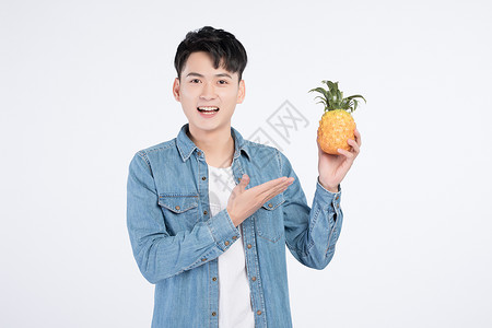 手持菠萝的青年男性高清图片