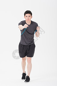 青年男子使用阻力带健身塑身背景图片