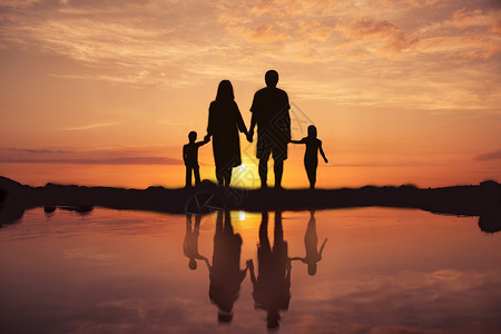 海滩玩耍夕阳下的一家人设计图片